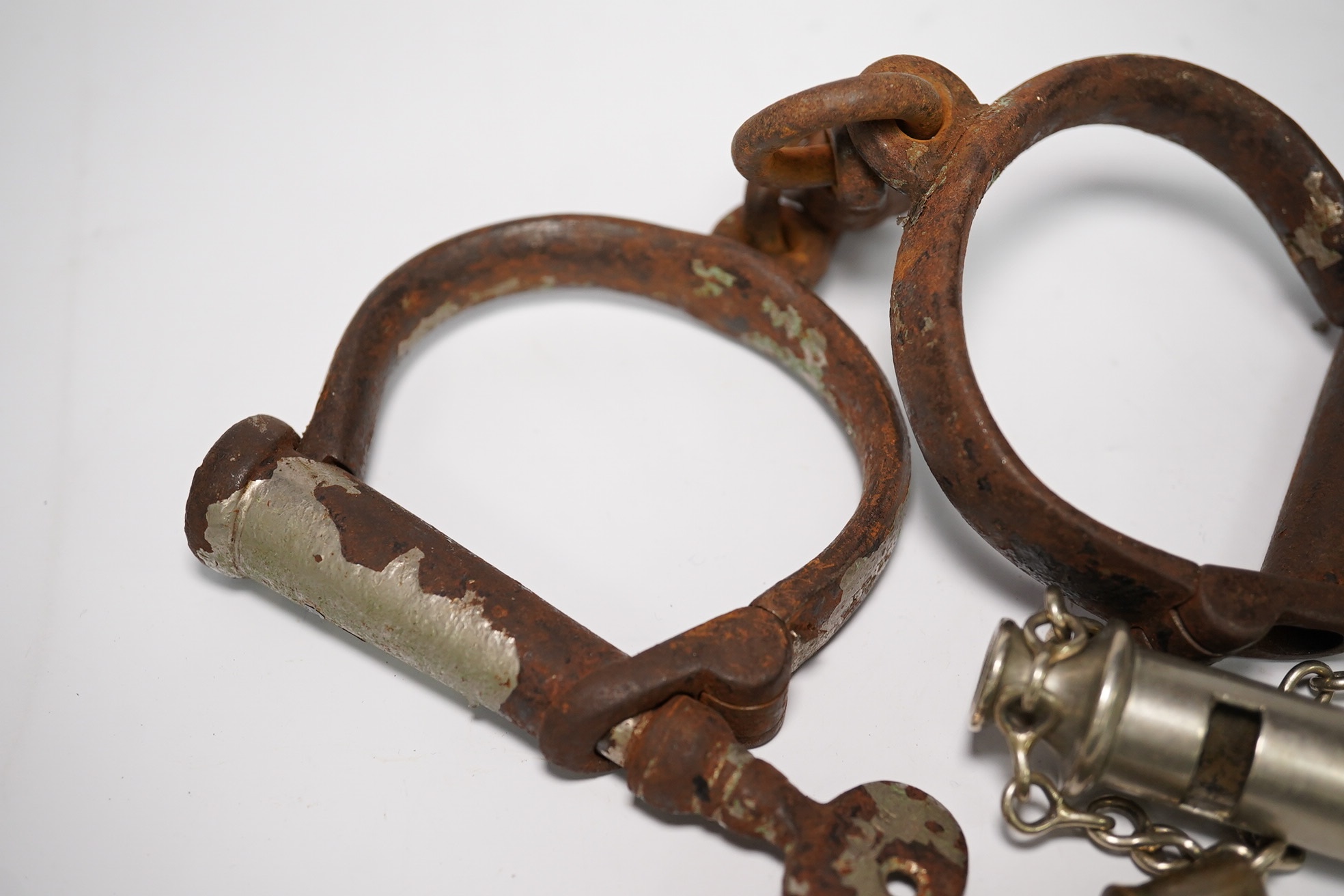 19th/20th century police hand cuffs and two whistles. Condition - poor